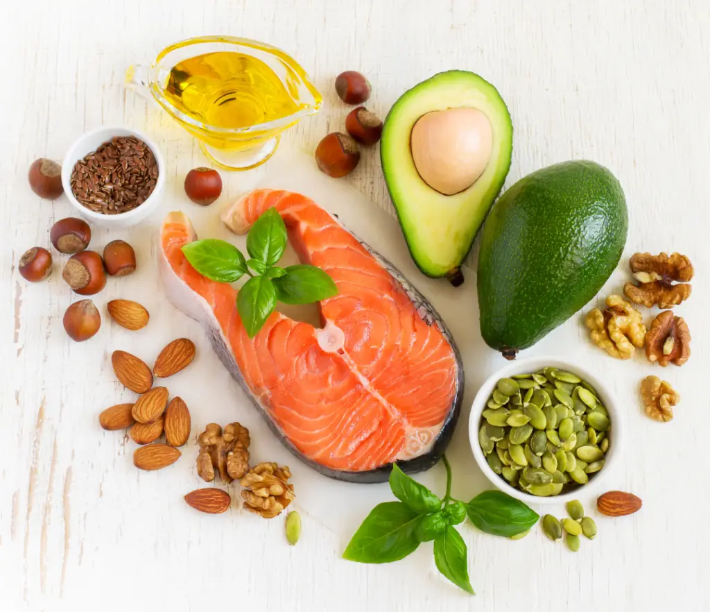 Benefits of healthy fats for wellness including salmon, coconut oil, olive oil, avocado, nuts, and seeds to support chiropractic care.