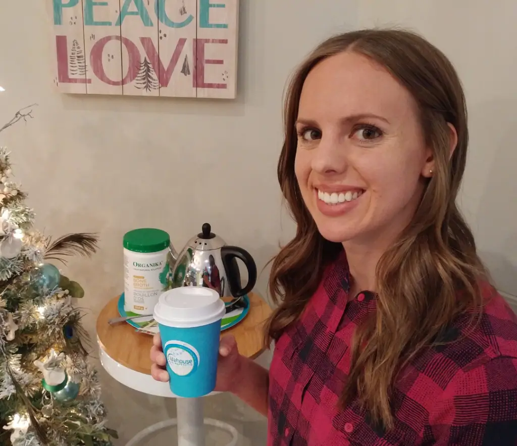Dr. Janna holding a cup enjoying the benefits of bone broth with organic bone broth mix and kettle in the background at LifeHouse Chiropractic in London Ontario.