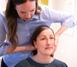 Image of Dr. Janna providing a neck adjustment to a woman since spinal misalignments, especially in the neck, can be a factor in developing carpal tunnel syndrome, and carpal tunnel relief can be found with chiropractic care. 