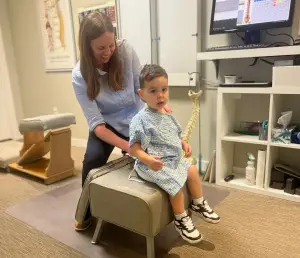 Two-year-old receiving gentle chiropractic adjustment as part of chiropractic care for kids and teens in London Ontario.