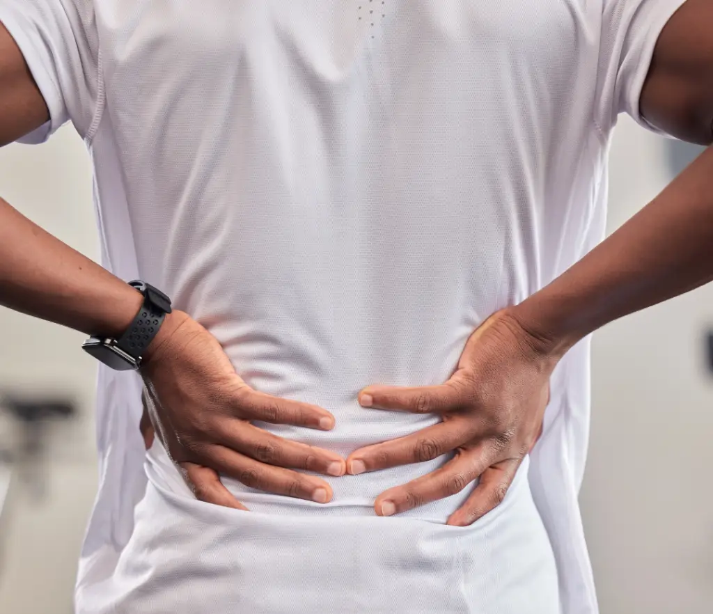 Back of a person holding their lower back, symbolizing the need for back pain relief in London Ontario.
