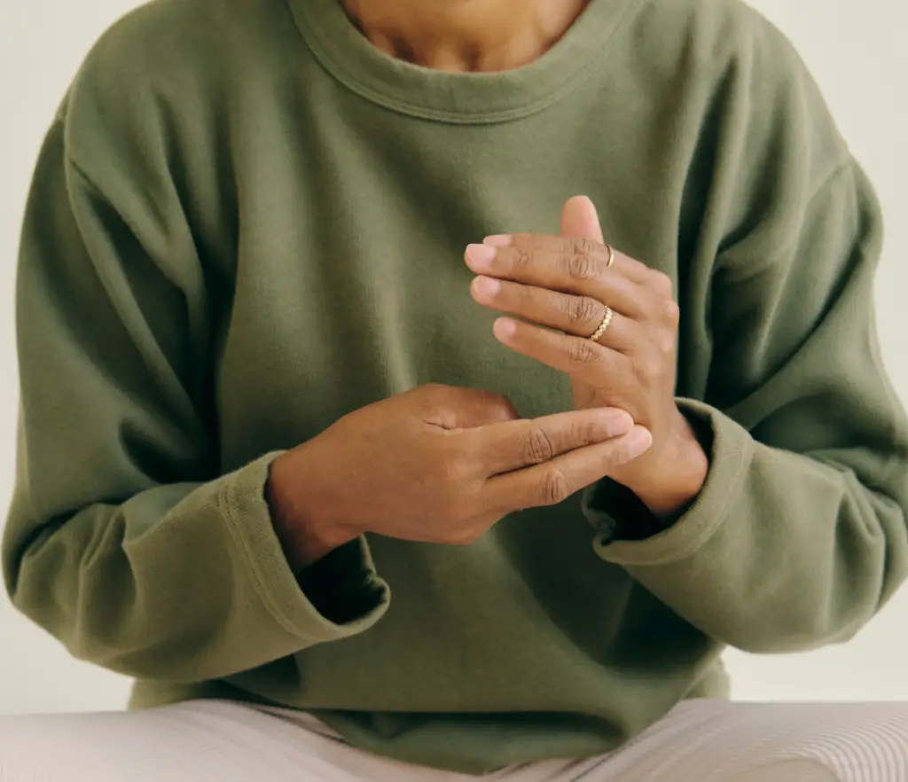 Woman practicing EFT tapping technique on her hand, showing that EFT complements chiropractic in London Ontario.
