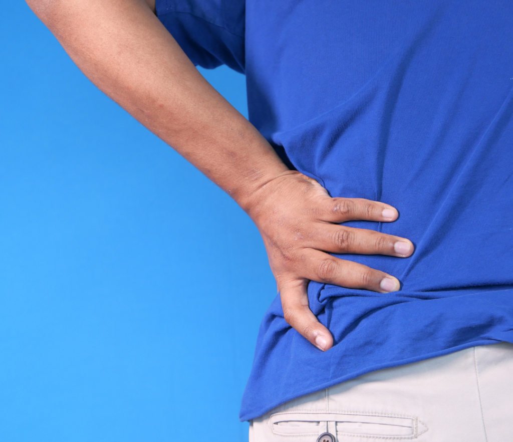Person holding their back in pain, illustrating the connection between pain and health.